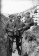 Drei Soldaten in einem ausgebauten Schützengraben 